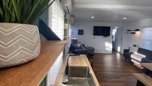 Een moderne keuken met een houten aanrecht, een inbouwspoelbak en een roestvrijstalen afzuigkap.