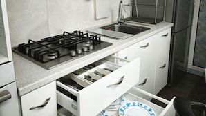 A modern kitchen with white cabinetry, a stainless steel range hood, a built-in sink, and a dishwasher. - Ένα ευχάριστο χώρο άνετο και εξυπηρέτηκο έχει όλες της άνεσης...μέσα στην πόλη.. (Kastelli)