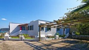 A modern house with a white exterior, a wooden pergola, and a view of the sea. - La Bella Forianella. Alloro (Forio)