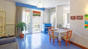 A dining area with a table and chairs, a potted plant, and a view of the outdoors. - La Bella Forianella. Alloro (Forio)
