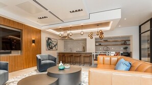 A modern living room with a sofa, two round coffee tables, and a kitchen in the background. - New penthouse unit in downtown Bellevue (Bellevue)