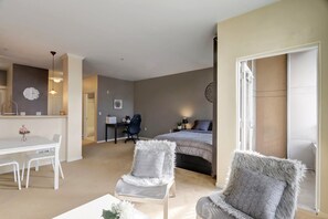 1 habitación, escritorio, tabla de planchar con plancha y ropa de cama