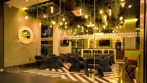 A lobby with a modern design, featuring a seating area with sofas and a patterned floor. - Hotel Antré Chapultepec (Guadalajara)