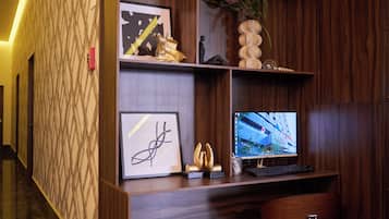 Un mostrador de recepción con una computadora, obras de arte enmarcadas y elementos decorativos.