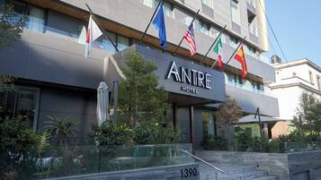 Welcome to the Antre Hotel, featuring a striking entrance with a large sign and flags.