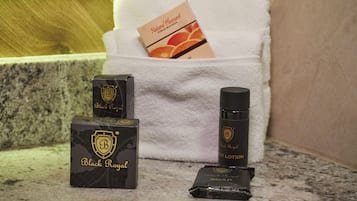 Cajas de jabón y lociones Royal negras, una barra de jabón y una caja de loción con sabor a naranja sobre una encimera de baño.