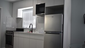 Frigorífico, microondas, placa de cocina y utensilios de cocina