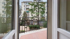 A balcony with a metal railing, a view of a multi-story building, and a tree. - Fabbroni 3 bedrooms in Florence by Mmega (Firenze)