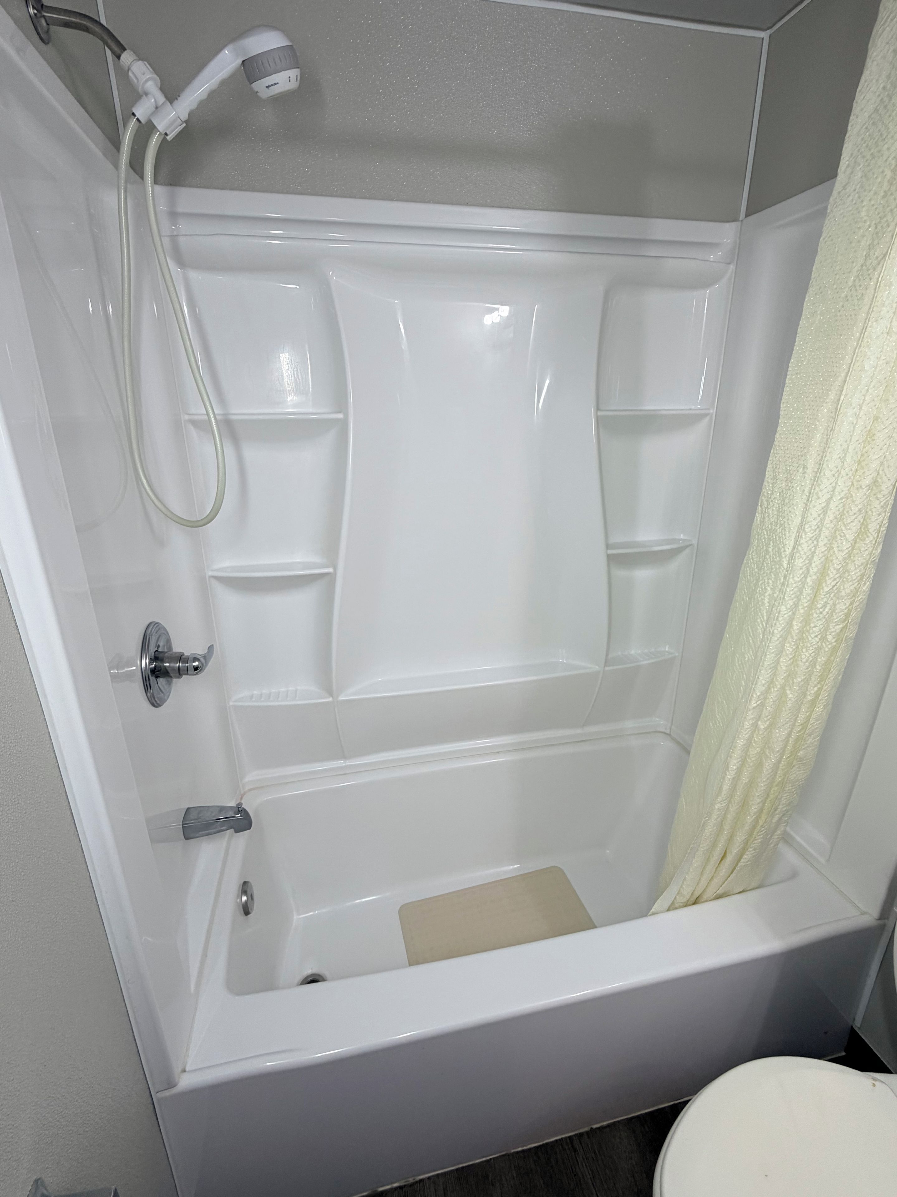 Une salle de bain moderne équipée d’une baignoire, d’une douche et de toilettes.