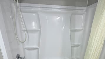 Une salle de bain moderne équipée d’une baignoire, d’une douche et de toilettes.