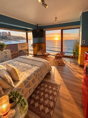 A bedroom with a large bed, a view of the sea, a balcony, and a cityscape. - PACIFICSUNSET CONCÓN (Concon)