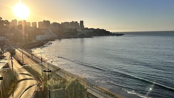 Eine Küstenstadt mit freiem Blick auf das Meer, einer Brücke und einer Gebäudereihe entlang der Uferlinie.