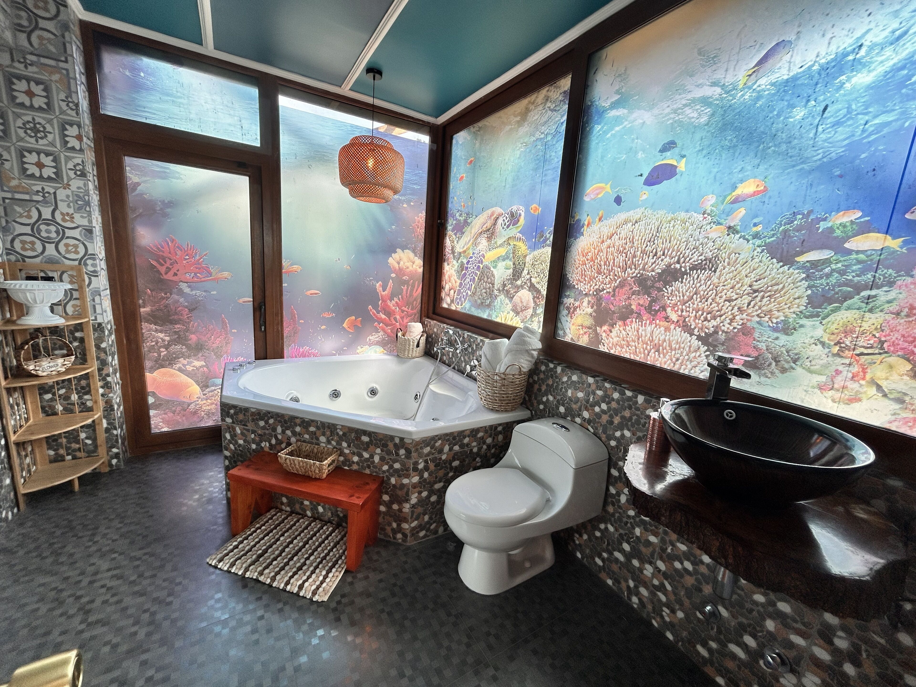 A bathroom with a large aquarium, a bathtub, and a sink.