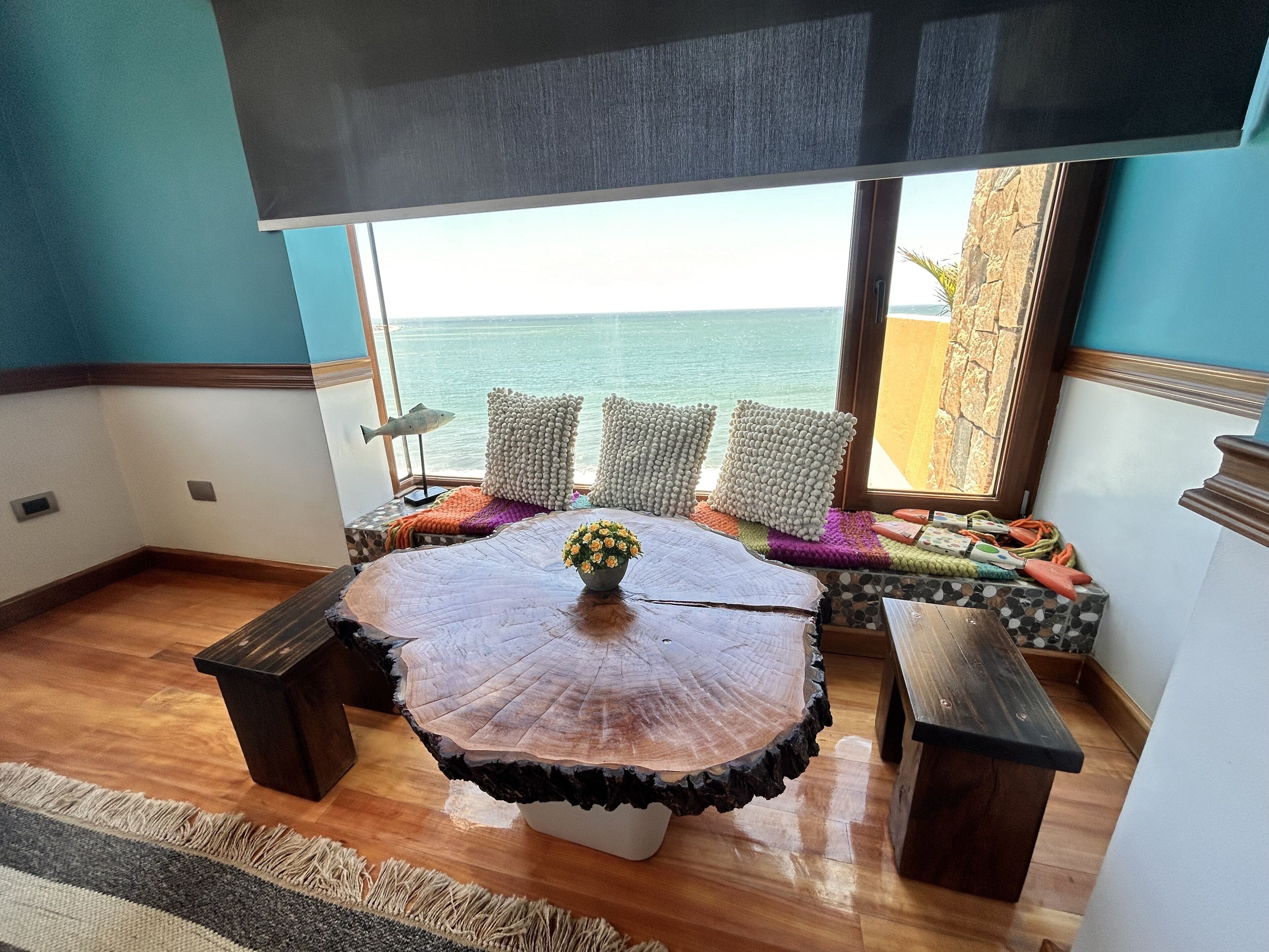 Un rincón acogedor con una mesa redonda, una planta en maceta y vistas al mar.