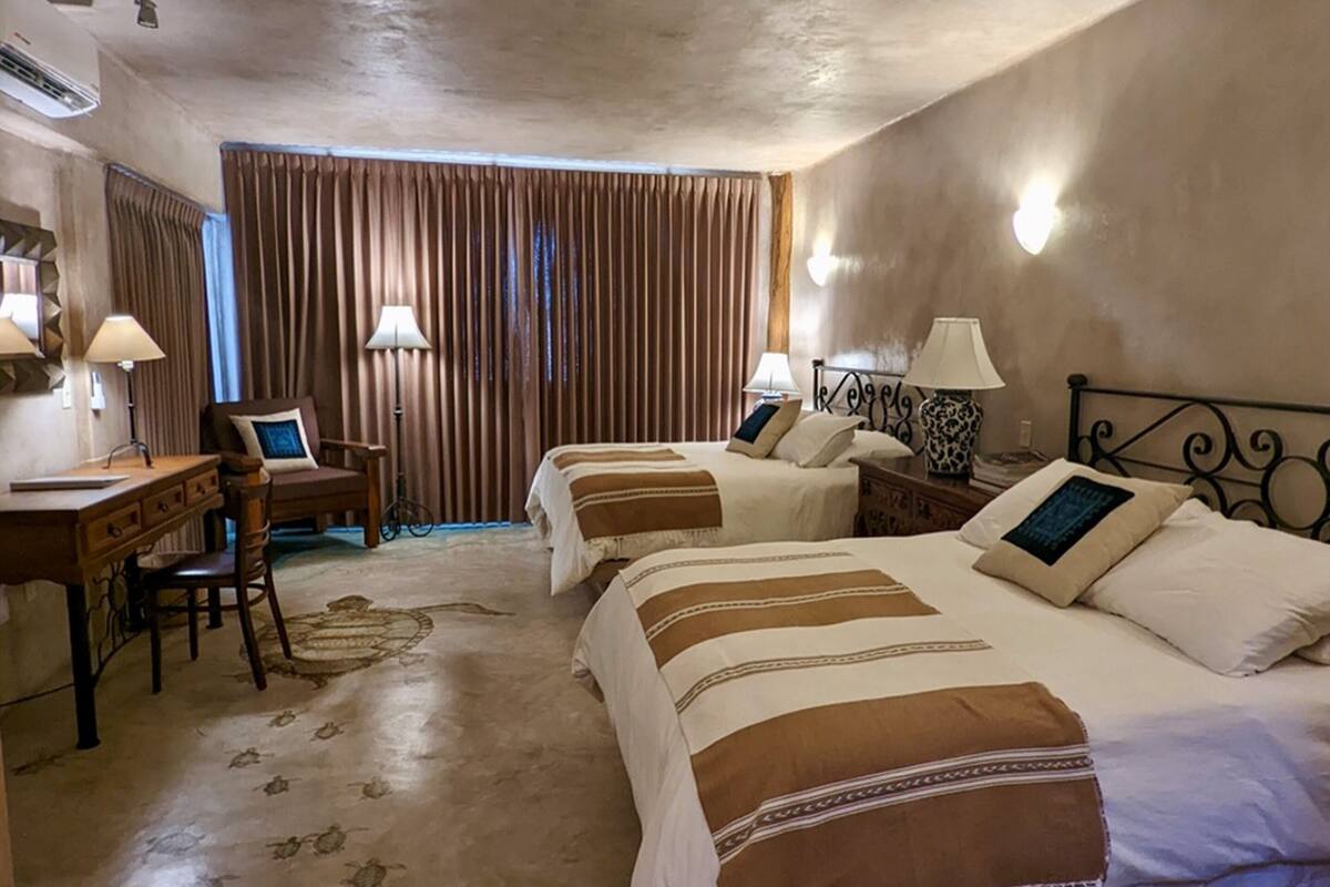 Een hotelkamer met twee bedden, een bureau en een stoel.