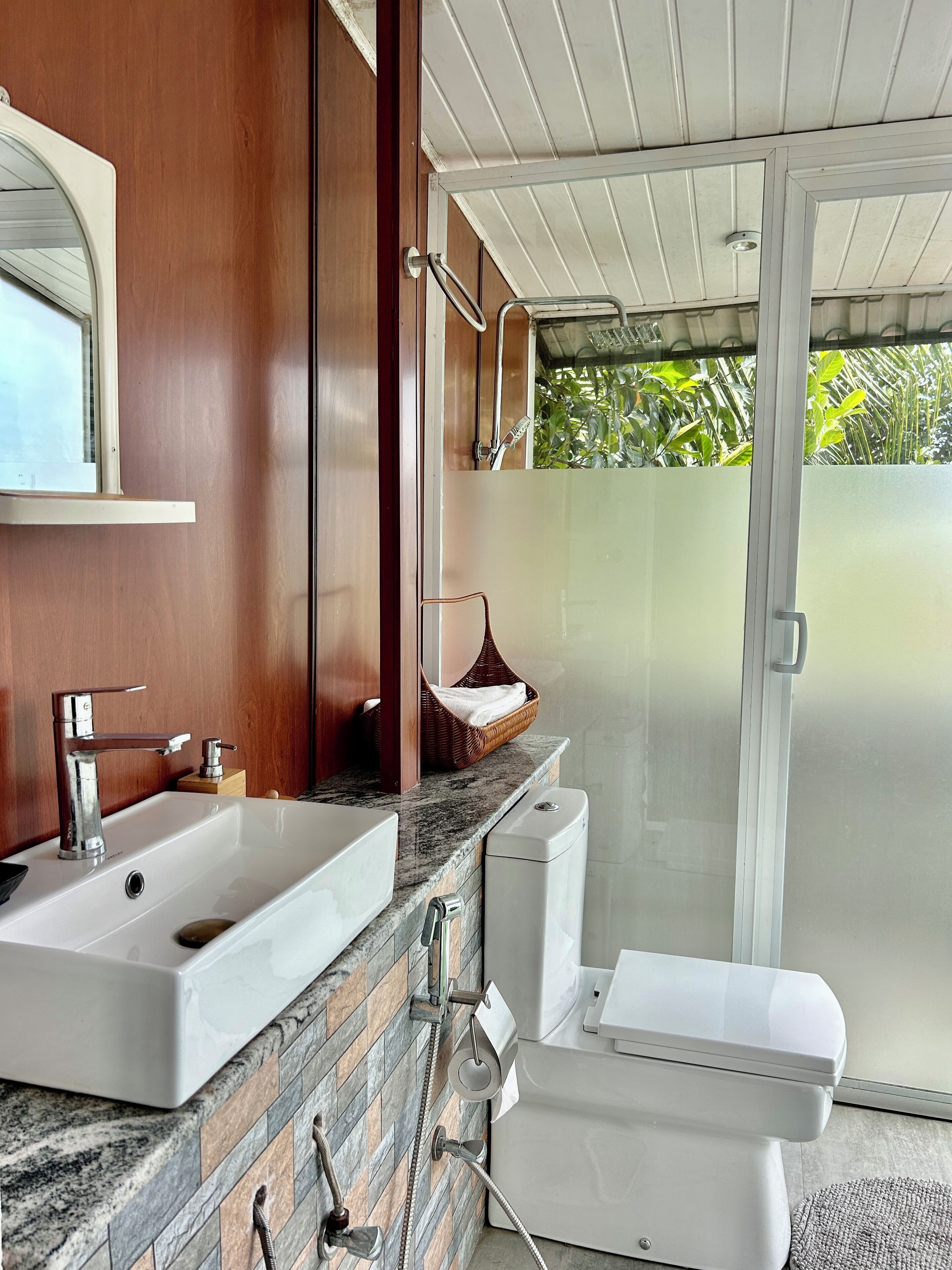 Un baño con lavamanos doble, inodoro y zona de ducha.