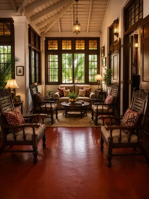 A room with a high ceiling, large windows, and a central coffee table surrounded by four armchairs. - Colonial Residence Kandy  (Kandy)