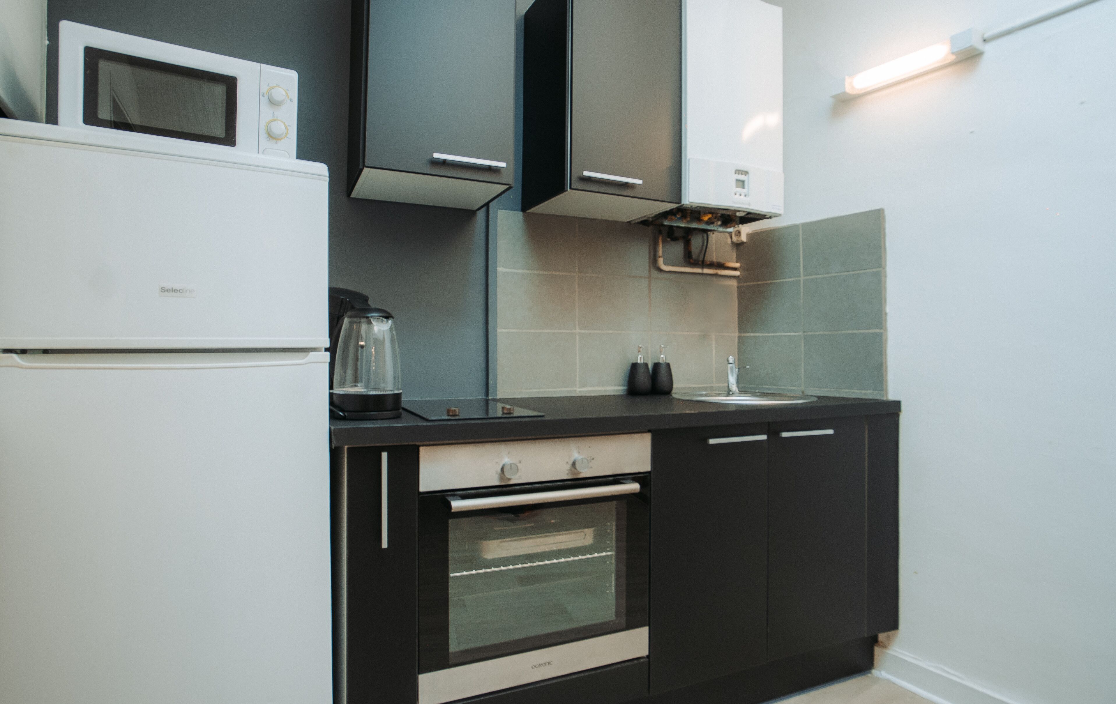 A modern kitchen with a built-in oven, microwave, and a coffee maker.
