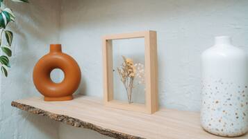 Ein Regal mit Holzrahmen, eine braune Vase und eine weiße Vase mit Tupfen.