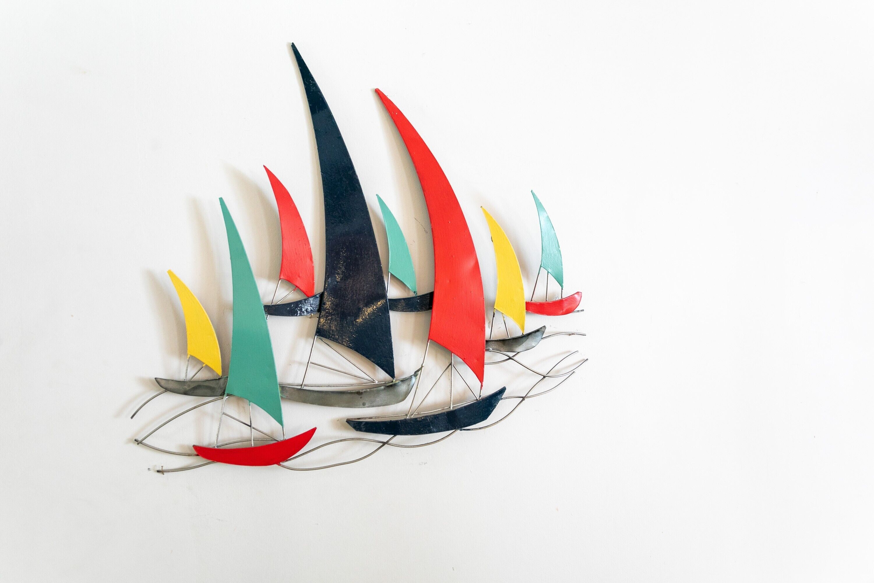 A sailboat model with multiple sails in various colors.