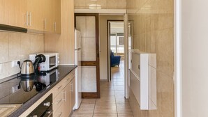 Una cocina moderna con microondas, hervidor y armarios.