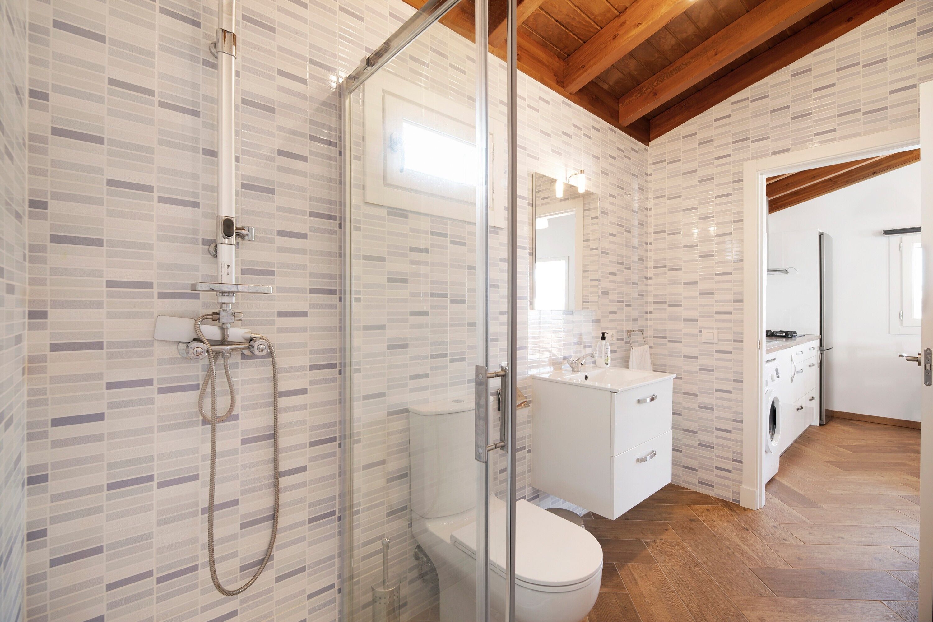 Ein modernes Badezimmer mit Duschkabine, Toilette und Waschbecken mit Spiegel.