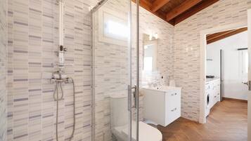 Ein modernes Badezimmer mit Duschkabine, Toilette und Waschbecken mit Spiegel.