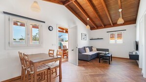 Ein geräumiger Wohnbereich mit Esstisch, Sofa und Holzboden.