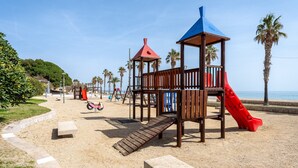 Ein Spielplatz mit Rutsche, Klettergerüsten und einer Bank.