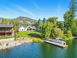 Una propiedad frente al lago con muelle, piscina y una casa grande con varias habitaciones.