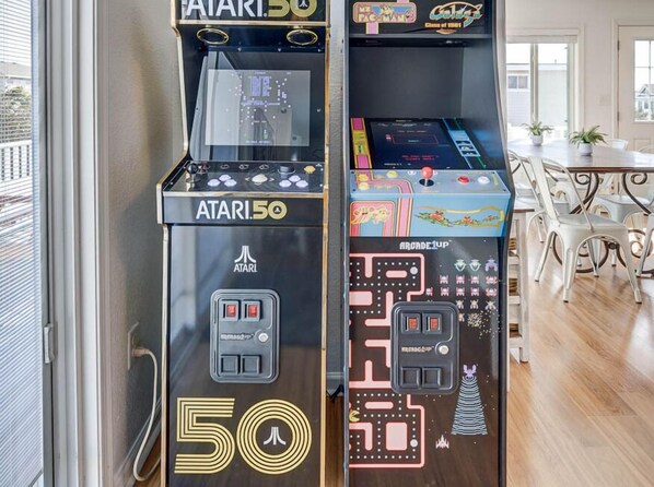 Una máquina de videojuegos retro, con el rótulo Atari 50, mostrando un juego de laberinto en el lado derecho.