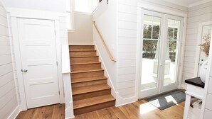 A staircase with wooden steps and white walls, leading to a door with glass panels. - Soundside, Private Pool, Den, Yard, Screened Porch, SH106, Turners Tide (Duck)