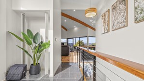 A modern interior with a staircase, potted plants, and artwork on the walls. - Tree Top Views - 4 Bedroom House (Rosetta)