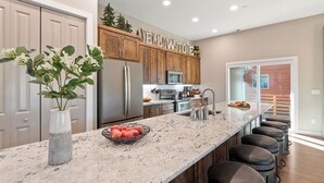 Une cuisine moderne avec un grand îlot central, des armoires en bois et une enseigne « Yellowstone » placée au-dessus des armoires.