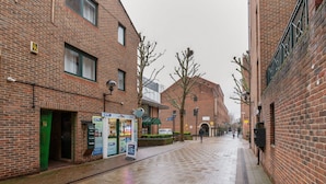 Een gebouw van baksteen met een groene luifel, een duidelijke ingang en een naambord.