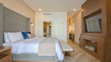 A modern bedroom with a large bed, bedside tables, a bench, a TV, and a wooden panel wall.