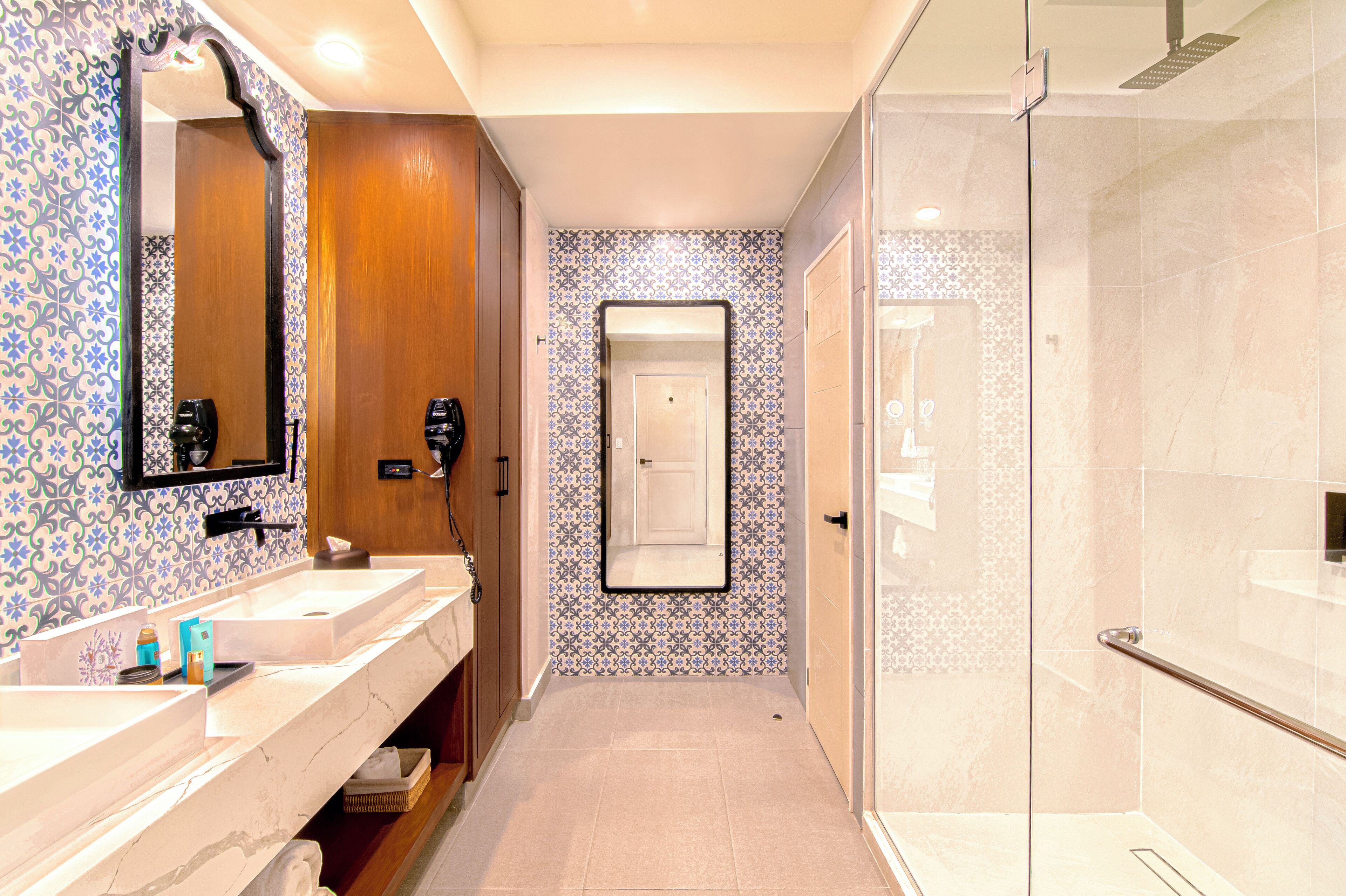 A modern bathroom with two sinks, a mirror, and a shower.