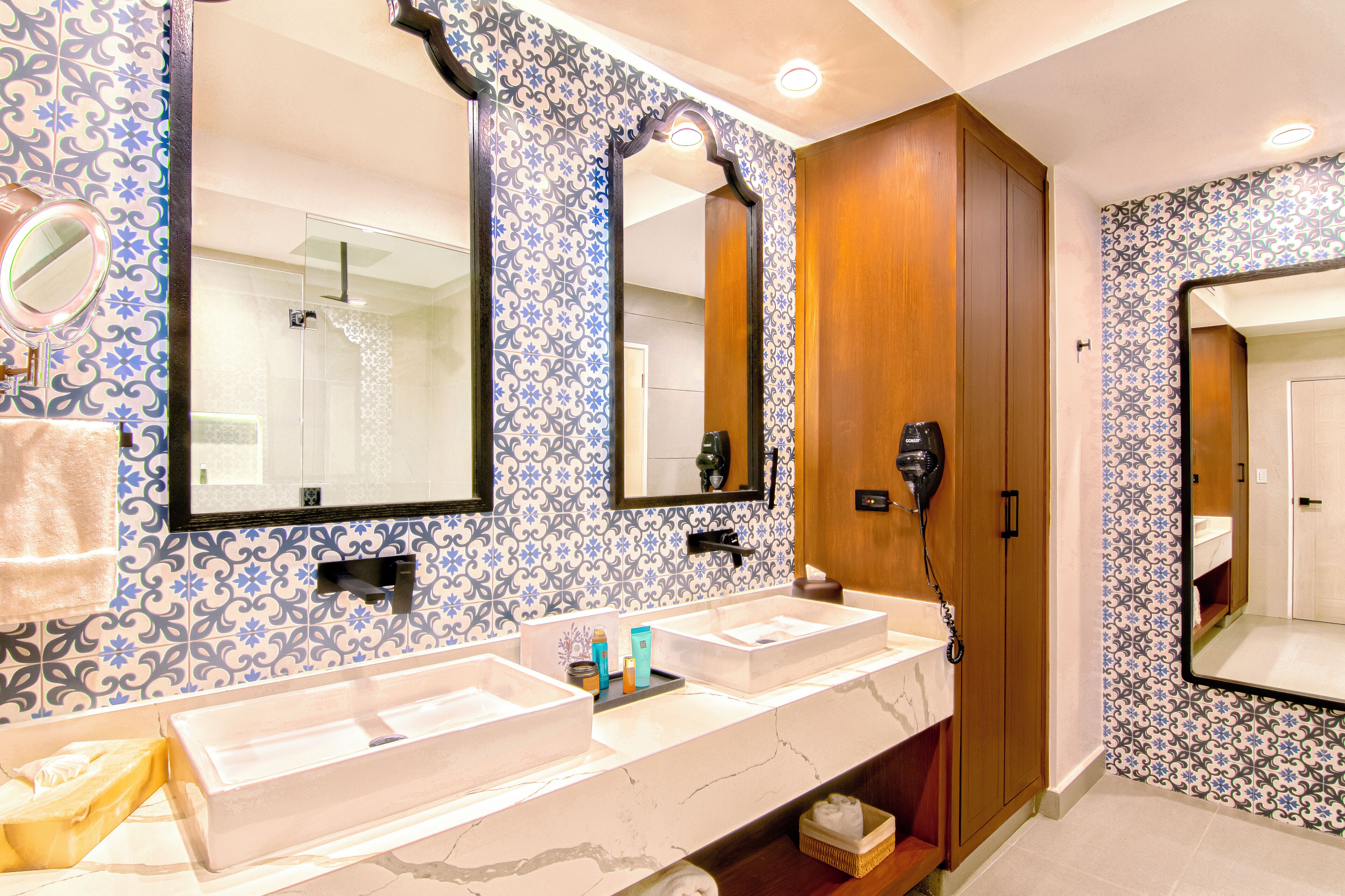Casa de banho com duas pias, um secador de cabelo e um espelho.