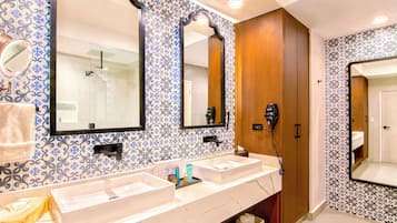 Casa de banho com duas pias, um secador de cabelo e um espelho.
