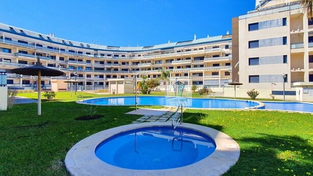 Ein Hotel mit mehreren Balkonen, einem zentral gelegenen Pool und einem angelegten Garten.