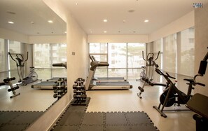 A modern gym with treadmills, elliptical machines, and free weights. - Pearl Hotel (Dhaka)