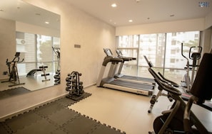 A gym with treadmills, elliptical machines, and free weights. - Pearl Hotel (Dhaka)