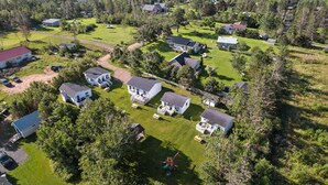 An aerial view of a residential area with multiple houses, a playground, and a road. - Drift Wood, Spacious 2 BRs, Living, Kitchen, Full Bathroom & a Patio  (York)