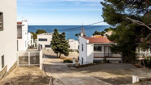 A residential street with white houses, a clear view of the sea, and a paved road. - Les Tonyines 67 - Apartment with views and terrace (Llança)