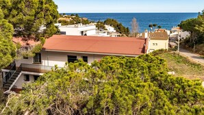 A coastal residential area with houses, a red-roofed building, and dense greenery. - Les Tonyines 67 - Apartment with views and terrace (Llança)