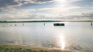 Un lac paisible, avec un ciel dégagé et une bouée au centre.