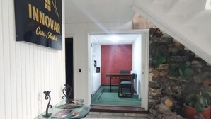 Un hall d’hôtel avec un comptoir d’accueil, un mur en pierre et un mur d’accent de couleur rouge.