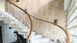 Un escalier en marbre avec une rampe en bois menant à un palier.