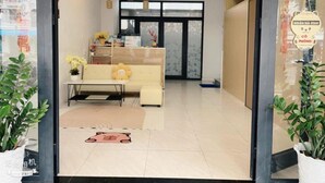 Un'area reception di un hotel con un divano, un tavolino e un tappeto decorativo.