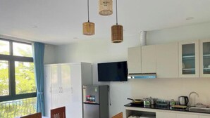 Una cucina moderna con frigorifero, piano cottura e forno a microonde. C'è un'area pranzo con tavolo e sedie.